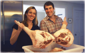 Amy and Sam Hainer holding pig legs.
